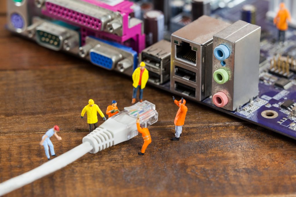 miniature engineer and worker plug in lan cable to computer