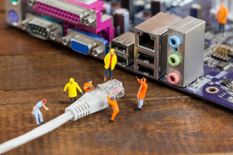 miniature engineer and worker plug in lan cable to computer